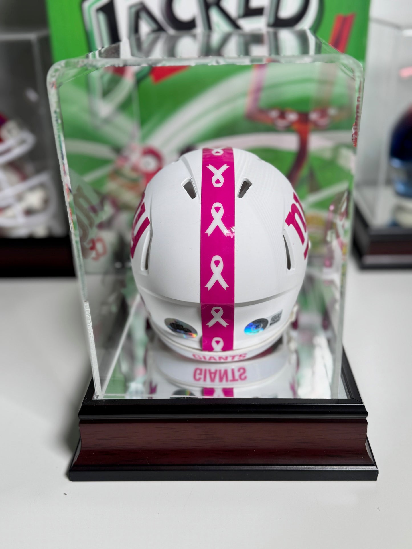 Back angle showing pink helmet shell, white chinstrap, and custom bumpers