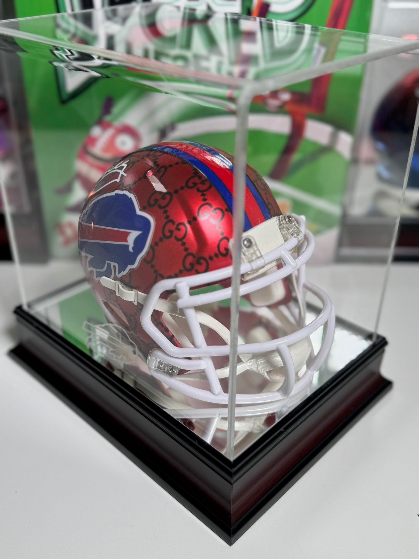 Close-up of Jim Kelly autograph on red and black Gucci print Buffalo Bills mini helmet