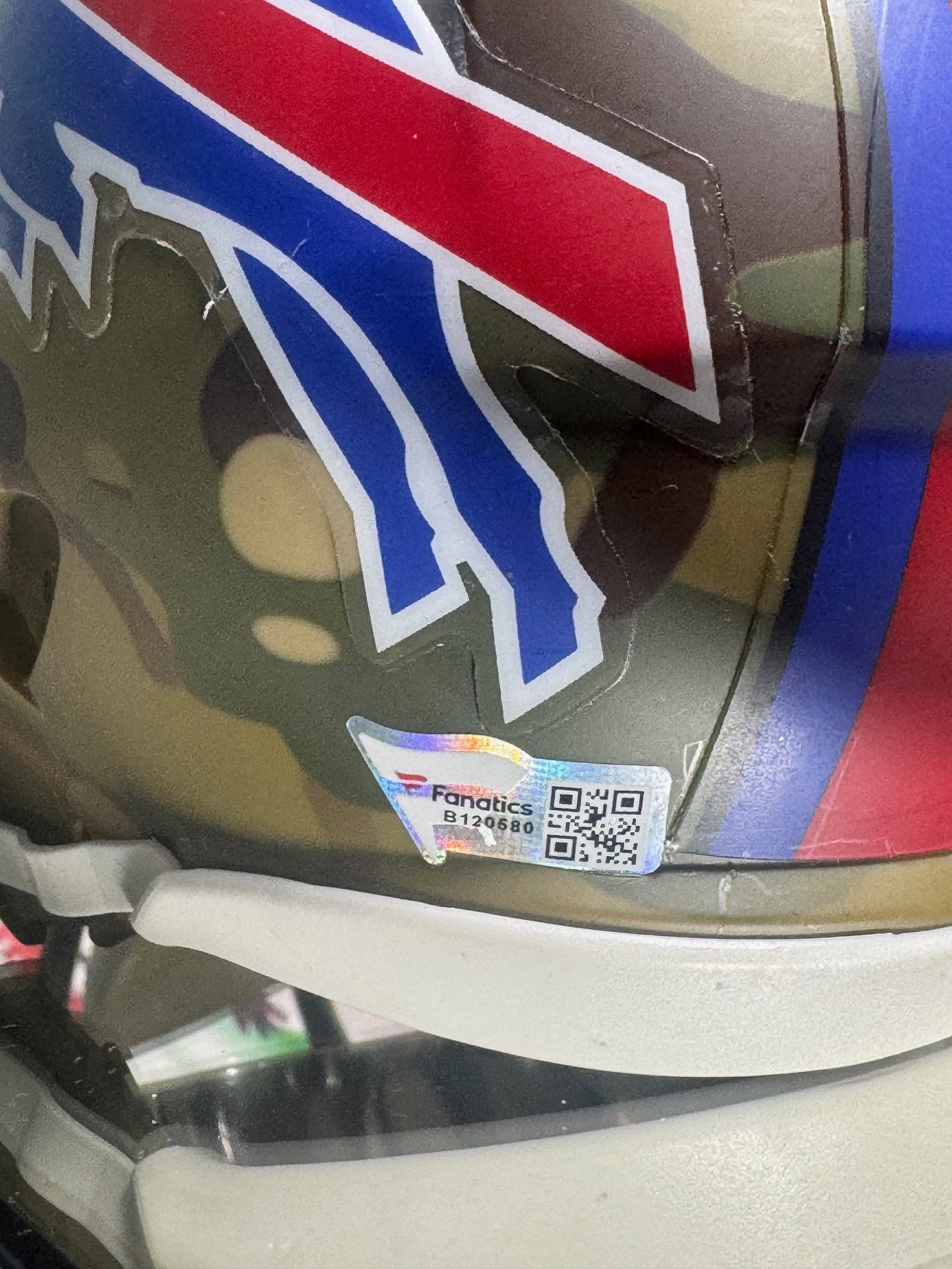 Side view of Salute to Service camo mini helmet signed by Jim Kelly